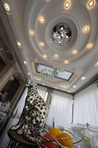 a ceiling with a chandelier and a table with fruits at Vila Lemic Postojna in Postojna