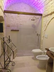 baño con aseo blanco y techo púrpura en Trulli: La pace dei sensi, en Alberobello