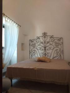 1 dormitorio con 1 cama con cabecero de metal en Trulli: La pace dei sensi, en Alberobello