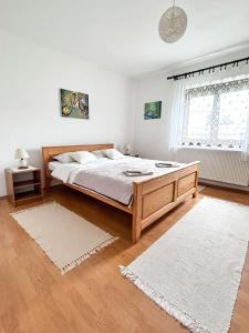 a bedroom with a large bed and two rugs at Apartment Milka in Korenica