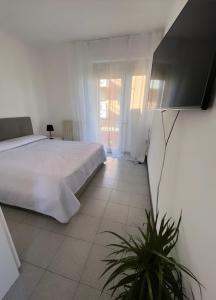 ein weißes Schlafzimmer mit einem Bett und einem Fenster in der Unterkunft Casa al mare in Cogoleto
