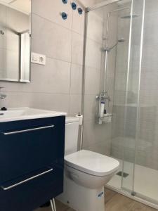 uma casa de banho com um WC e uma cabina de duche em vidro. em Precioso Apartamento em Puerto de Mazarrón