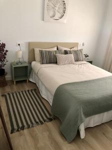 um quarto com uma grande cama branca com almofadas em Precioso Apartamento em Puerto de Mazarrón