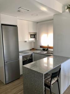 eine Küche mit Küchengeräten aus Edelstahl und einer Theke in der Unterkunft Precioso Apartamento in Puerto de Mazarrón