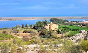 a house on a hill next to a body of water at Maison de la Lagune in Oualidia