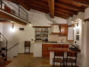 - une cuisine avec des placards en bois, une table et des chaises dans l'établissement Il Loft del Lago, à Anguillara Sabazia