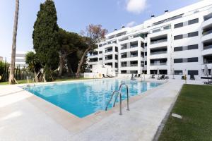 a swimming pool in front of a building at Brand new apartment with pool and SEA VIEW in Marbella in Marbella