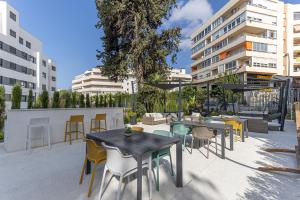 a patio with tables and chairs and buildings at Brand new apartment with pool and SEA VIEW in Marbella in Marbella