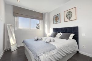 a white bedroom with a large bed with a window at Brand new apartment with pool and SEA VIEW in Marbella in Marbella