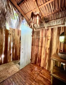 a room with a door in a room with wooden walls at Buena Onda Bungalows in Santa Teresa Beach