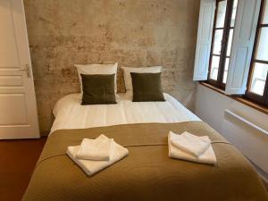 1 dormitorio con 1 cama con 2 toallas en "Le central" Appart Arles, en Arles