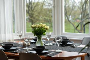 a wooden table with a vase of flowers on it at Entire home in Streatham with lovely views & ultra fast Wi-Fi in Norbury