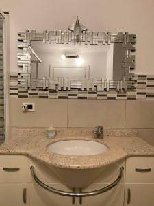 ein Bad mit einem Waschbecken und einem Spiegel in der Unterkunft Appartamento a Rovereto in Rovereto