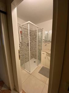 ein Bad mit einer ebenerdigen Dusche und einem Waschbecken in der Unterkunft Appartamento a Rovereto in Rovereto