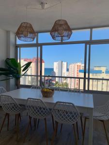 a dining room table and chairs with a view of the ocean at ÁTICO COPACABANA in Playa de Gandia