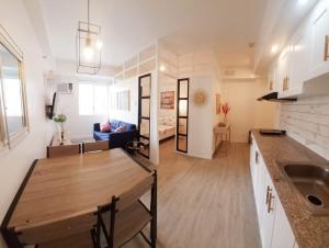 a kitchen and living room with a table and a couch at Ecostay @ Amaia in Bacolod