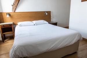 A bed or beds in a room at Le Relais Des Templiers