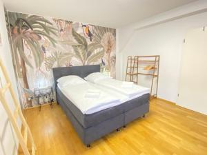 a bedroom with a bed with a mural on the wall at LUXOMES - Tropical & Streetart Style - Old Town Apartments - Central Ingolstadt in Ingolstadt