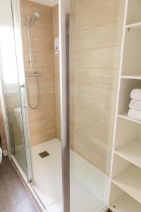 a shower with a glass door in a bathroom at Le Relais Des Templiers in Beaugency