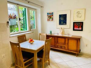 a dining room with a table and chairs and a desk at Apartments Villa Rosa in Split