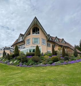 a large house with a landscaping in front of it at Sunside Ferien Wellness Oase Hotel Apartment's Schwarzwald am Schluchsee in Schluchsee