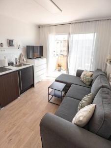 uma sala de estar com um sofá e uma cozinha em Studio / 900m de la plage em Fréjus