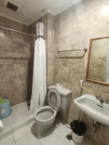 een badkamer met een toilet en een wastafel bij warm makati in Manilla
