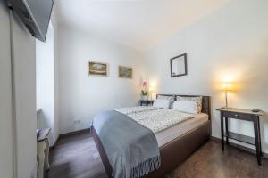 ブダペストにあるMargit Apartmentの小さなベッドルーム(ベッド1台、テレビ付)