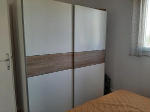 Schlafzimmer mit weißen Schränken und einem Bett in der Unterkunft Apartman-Kuzminski-Kraje14 in Vodice