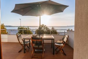 a table and chairs on a balcony with an umbrella at LA CASA DI IRENE in Alghero