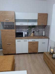 a kitchen with white cabinets and a microwave at Apartman-Kuzminski-Kraje14 in Vodice