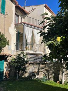 a large building with a balcony and a tree at Lo studio di Gabriella in Bolsena