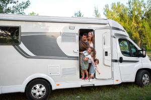 eine Familie, die hinten in einem weißen Wohnwagen steht in der Unterkunft Ebermannsmühle in Lauscha