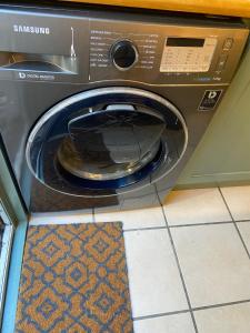 a washing machine with a blue bowl inside of it at A Garden Retreat in Kensal Green in London