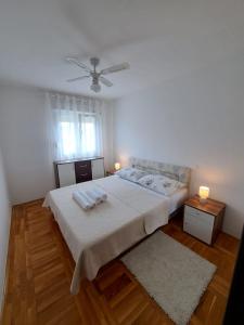 een slaapkamer met een groot bed en 2 handdoeken bij Apartman Dujma in Split