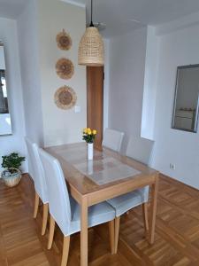 een eettafel met witte stoelen en een eetkamer bij Apartman Dujma in Split