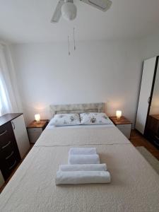 een slaapkamer met een bed met twee witte handdoeken erop bij Apartman Dujma in Split