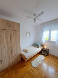 een slaapkamer met een bed en een plafondventilator bij Apartman Dujma in Split