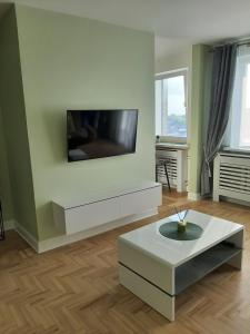 uma sala de estar com uma televisão de ecrã plano na parede em Visinskio apartamentai em Šiauliai