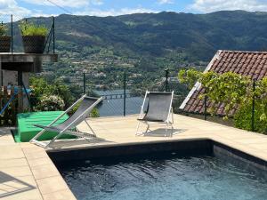 two chairs sitting next to a swimming pool at Casa da Lage - Gerês - Piscina privada in Geres