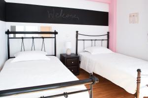 two beds in a bedroom with a black and white wall at Apartment in Athens, Pagrati in Athens