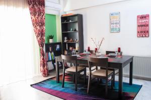uma sala de jantar com uma mesa e cadeiras num tapete em Apartment in Athens, Pagrati em Atenas