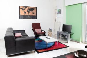 uma sala de estar com um sofá e uma televisão em Apartment in Athens, Pagrati em Atenas