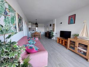 a living room with a pink couch and a tv at Family Relax Apartment in Alcudia