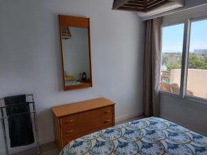 a bedroom with a bed and a dresser and a mirror at Family Relax Apartment in Alcudia