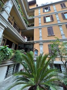 budynek z palmą przed nim w obiekcie Skyline Silence Suite w Mediolanie