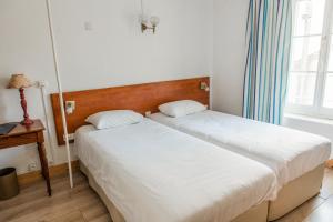 A bed or beds in a room at Le Relais Des Templiers