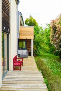 奧賽的住宿－Maison contemporaine au coeur de Paris-Saclay，木人行道上设有红色长椅的房子