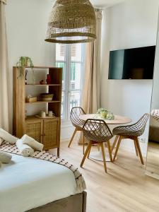 een woonkamer met een tafel en stoelen en een televisie bij Studio centre cannes in Cannes