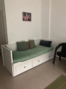 a white couch with green pillows on it in a room at Éva apartman in Balatonboglár